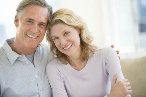 middle-age-coupleseated-indoors-smiling