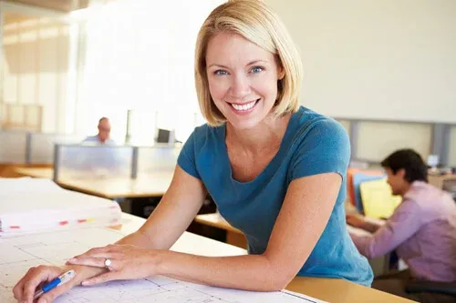 woman-smiling-at-drafting-table-web